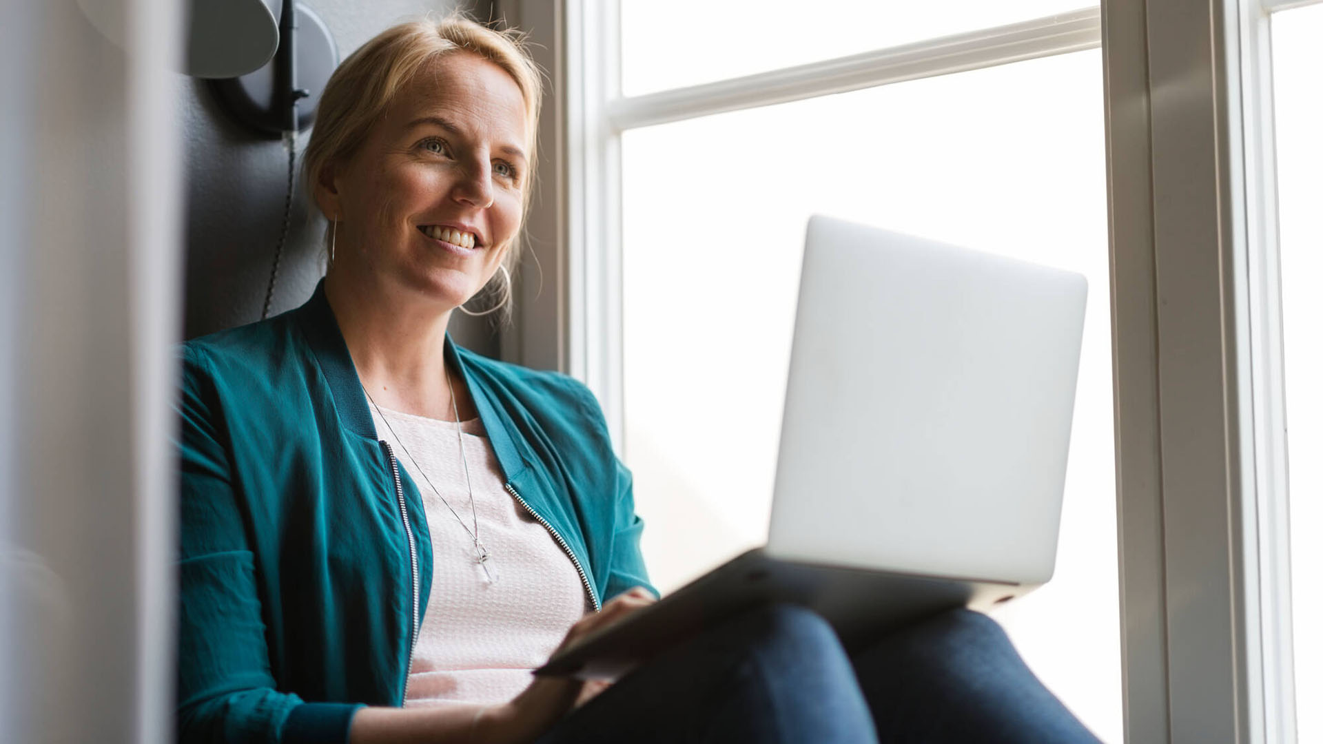 Kvinna i fönster med dator