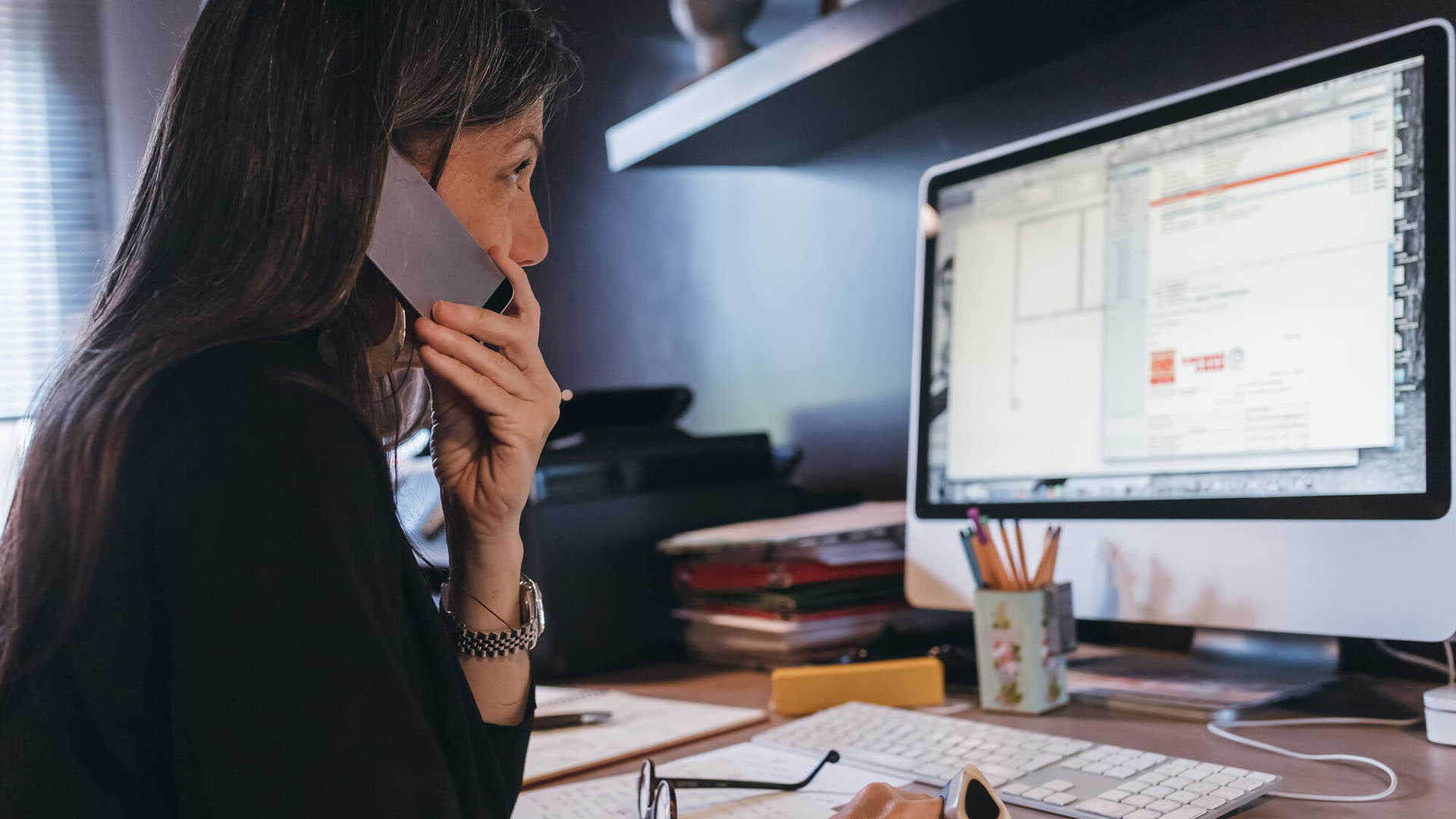 Kvinna i mobil vid dator