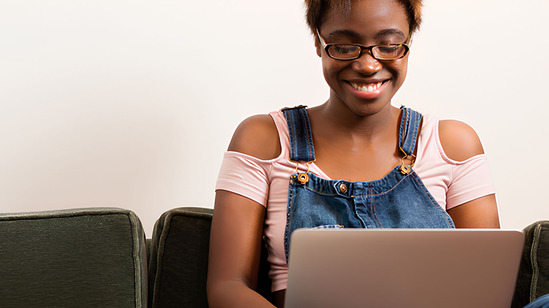 Kvinna i soffa vid dator