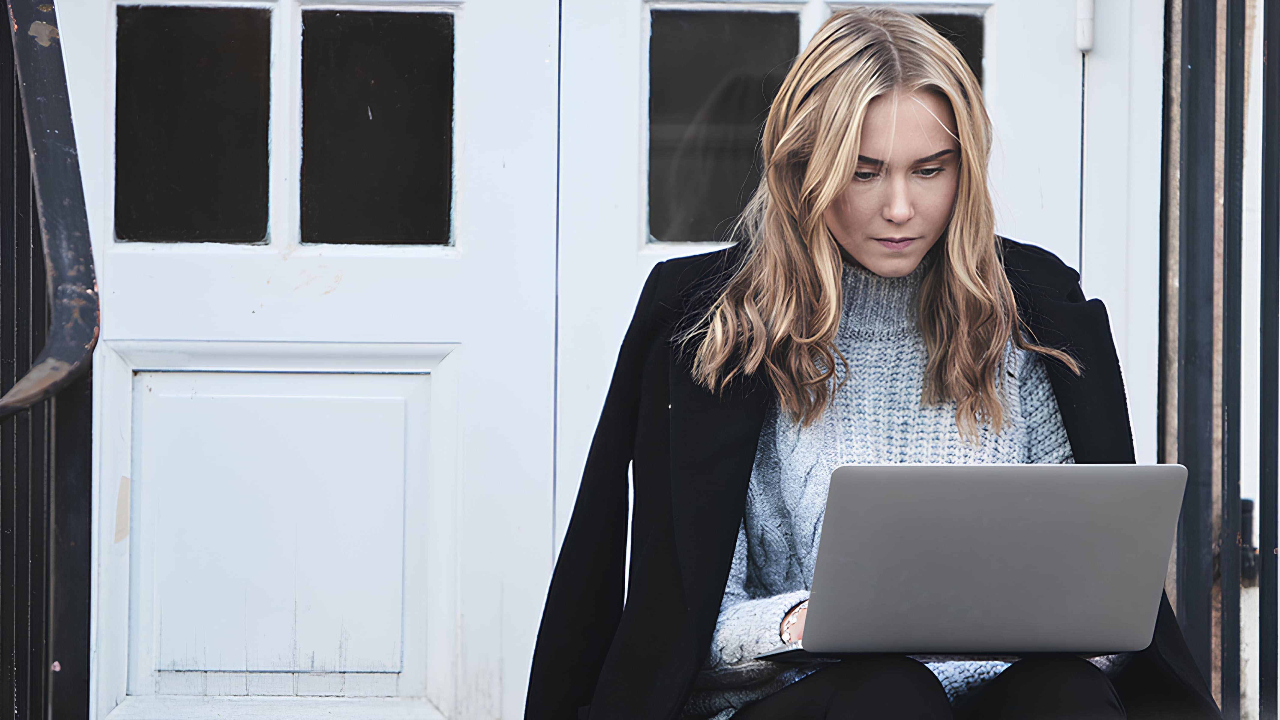 Kvinna med dator på trappa