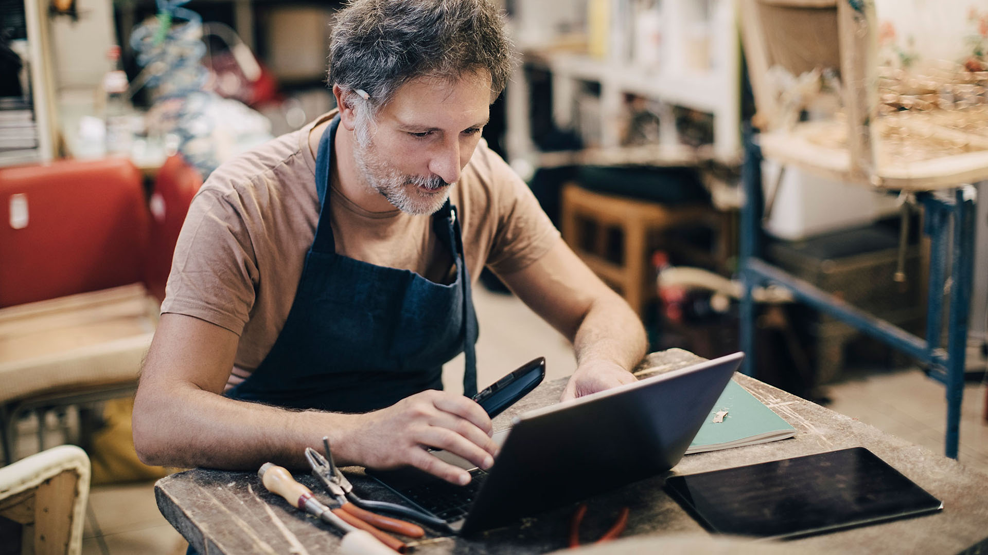 Man i verkstad vid dator