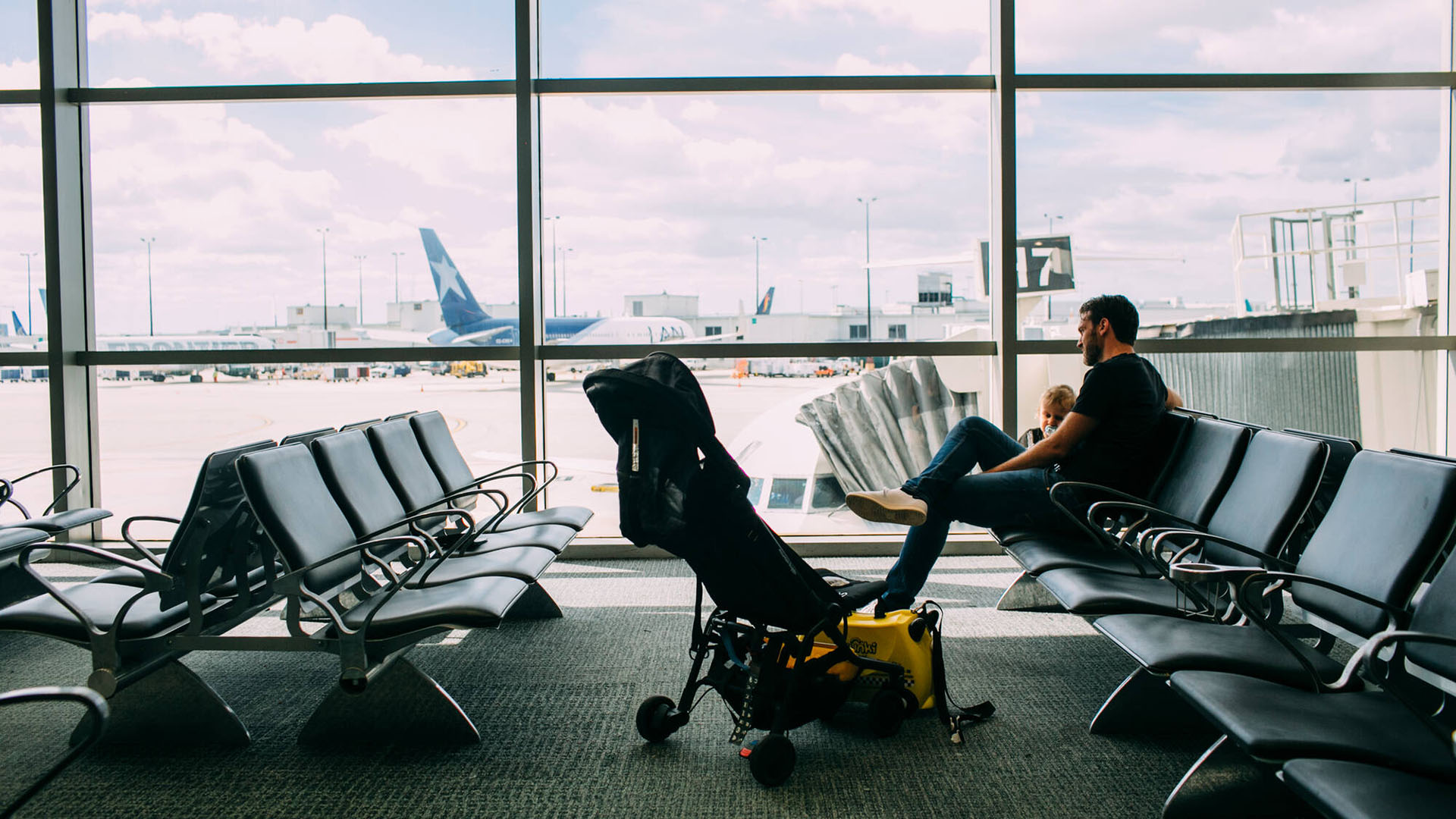Man med barn på flygplats