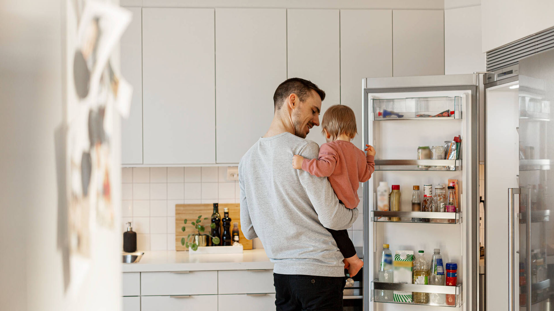 Pappa och barn vid kylskåp
